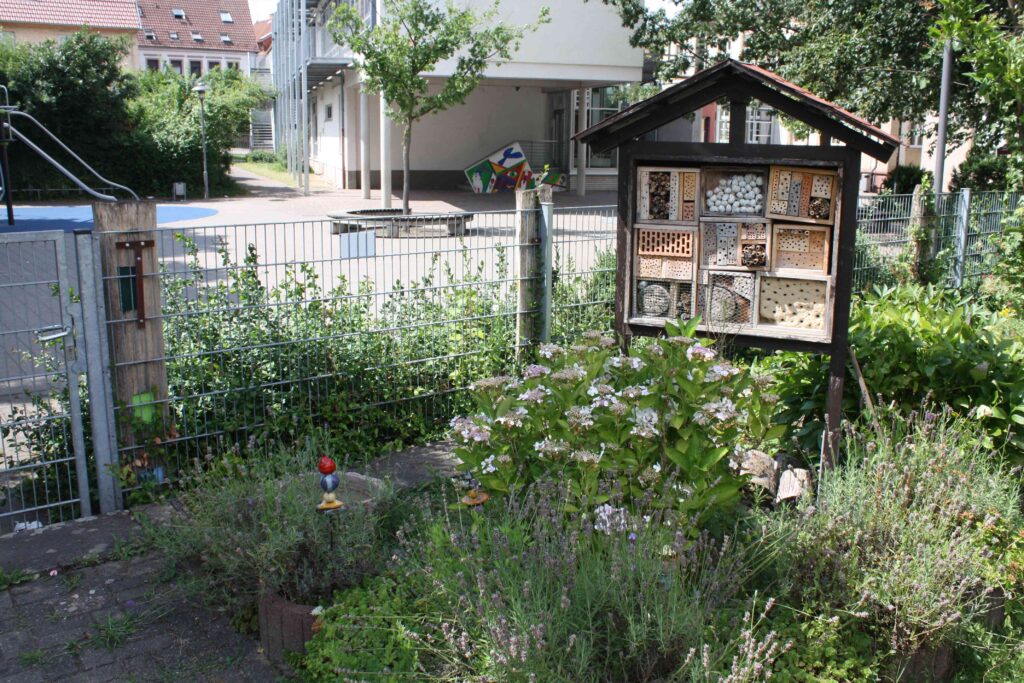 Insektenhotel zwischen blühenden Stauden