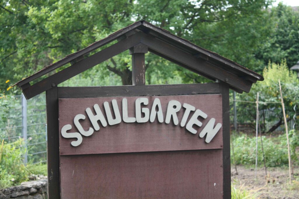 Holzschild „Schulgarten“ am Eingang