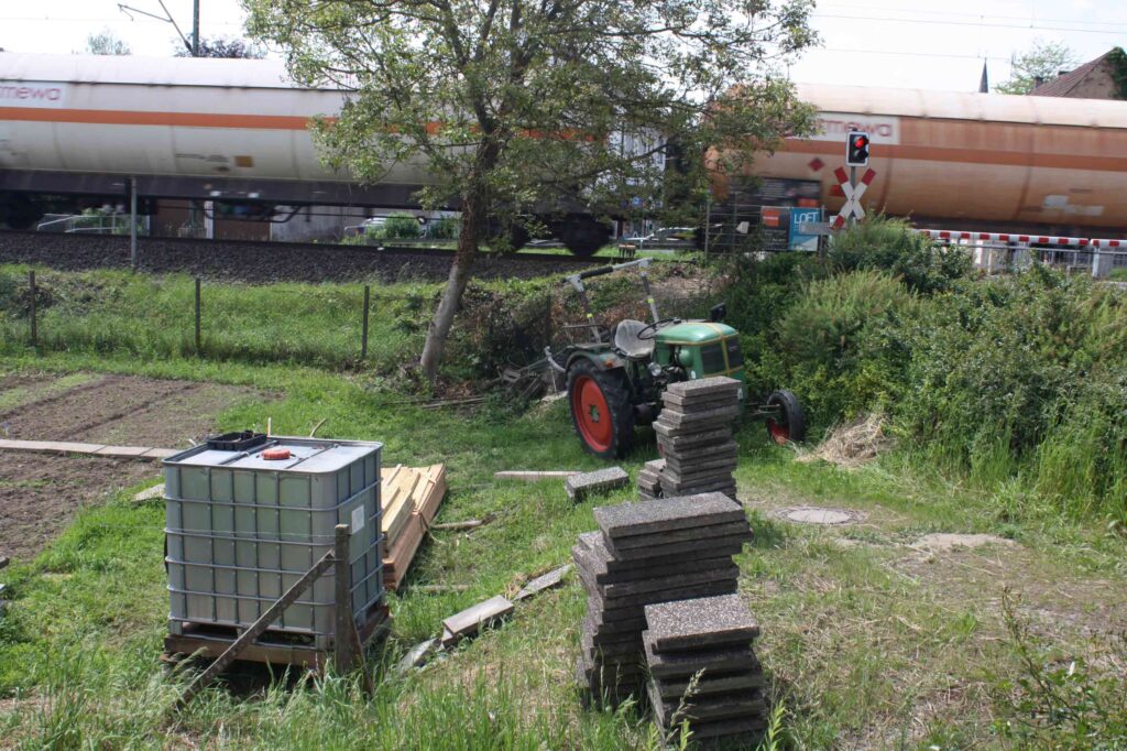 Baumaterial und Wassertank, im Hintergrund ein Güterzug